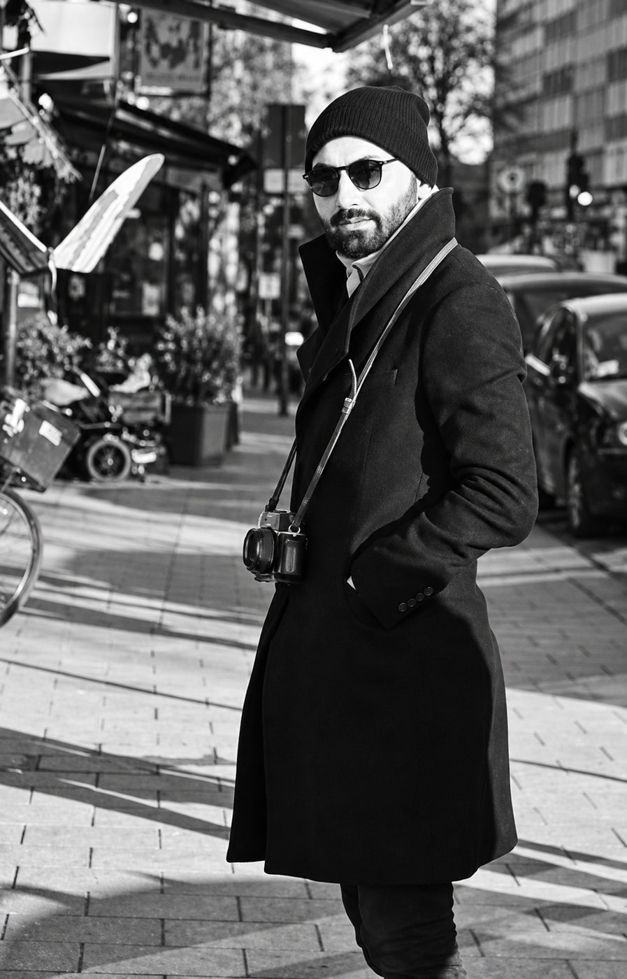 Oguzhan Erim on a Stockholm street, camera over his shoulder